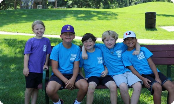 Group of children sitting together on a park bench