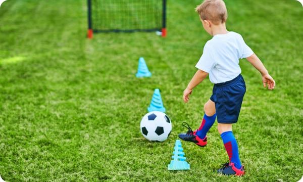 Little Boy Practising Soccer Outdoors