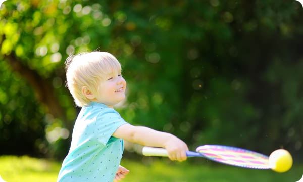 Kid Playing Badminton in Summer Park