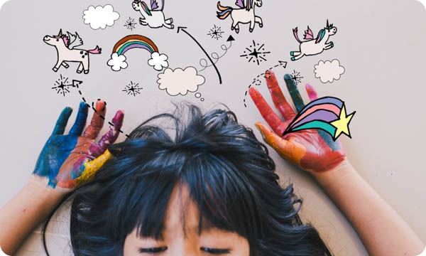 A Girl Laying down with Painted Hands Dreaming about Unicorns and Rainbows