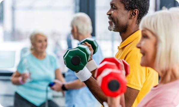 Selective Focus of Interracial Mature Couple Doing Exercise with Dumbbells at Gym