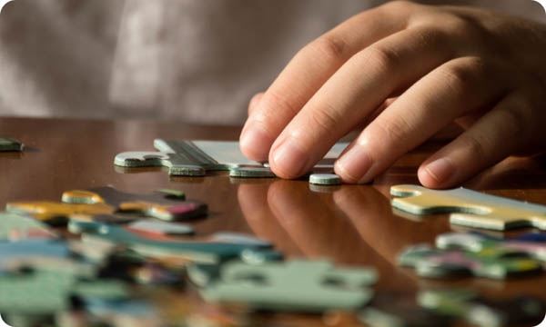 Detail of a Hands Doing a Puzzle at Home