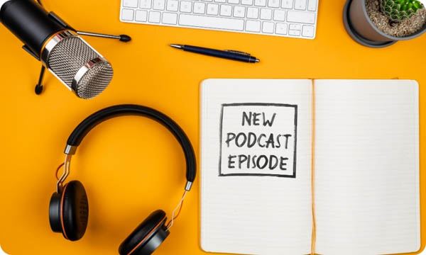 Text NEW PODCAST EPISODE on Notepad on Desk with Microphone