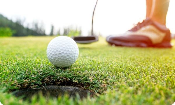 Golfer Woman Putting Golf Ball on the Green Golf