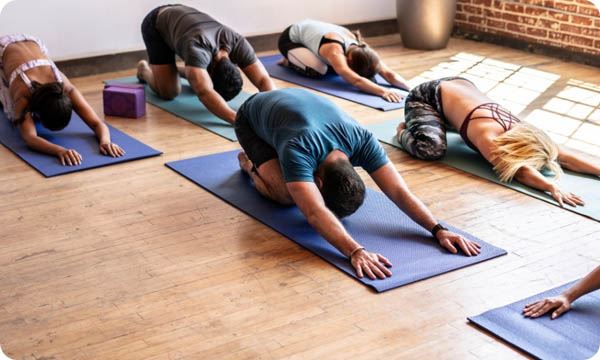 Women Practicing Yoga at Health Club