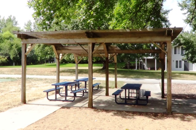A picnic shelter with 3 picnic tables in a city park