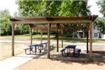 A picnic shelter with 3 picnic tables in a city park